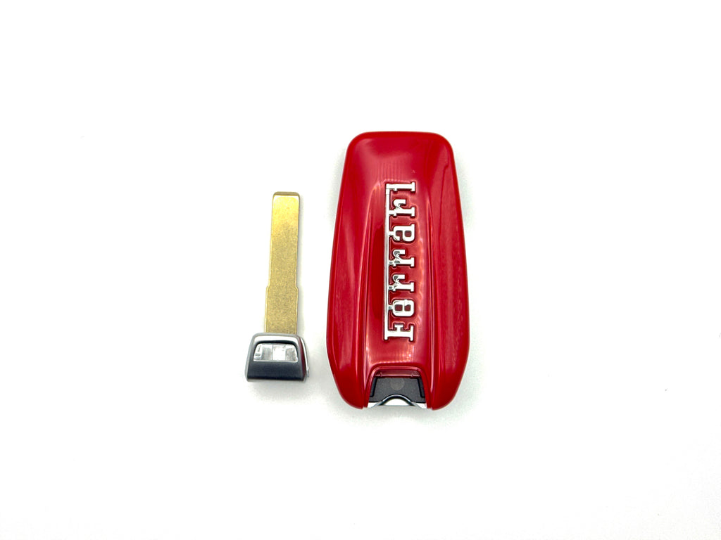 Red Ferrari key fob cover with key on a white background with key blade out